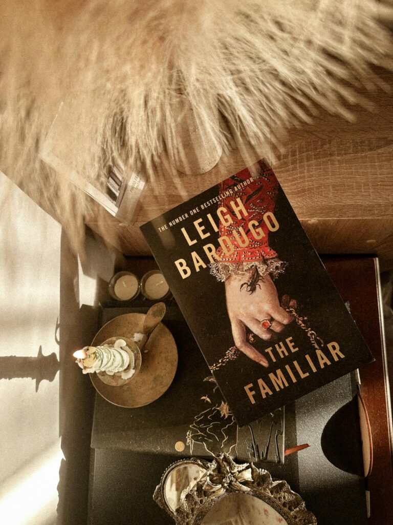 A still life photograph featuring a book titled 'The Familiar' with artistic decor and warm tones.